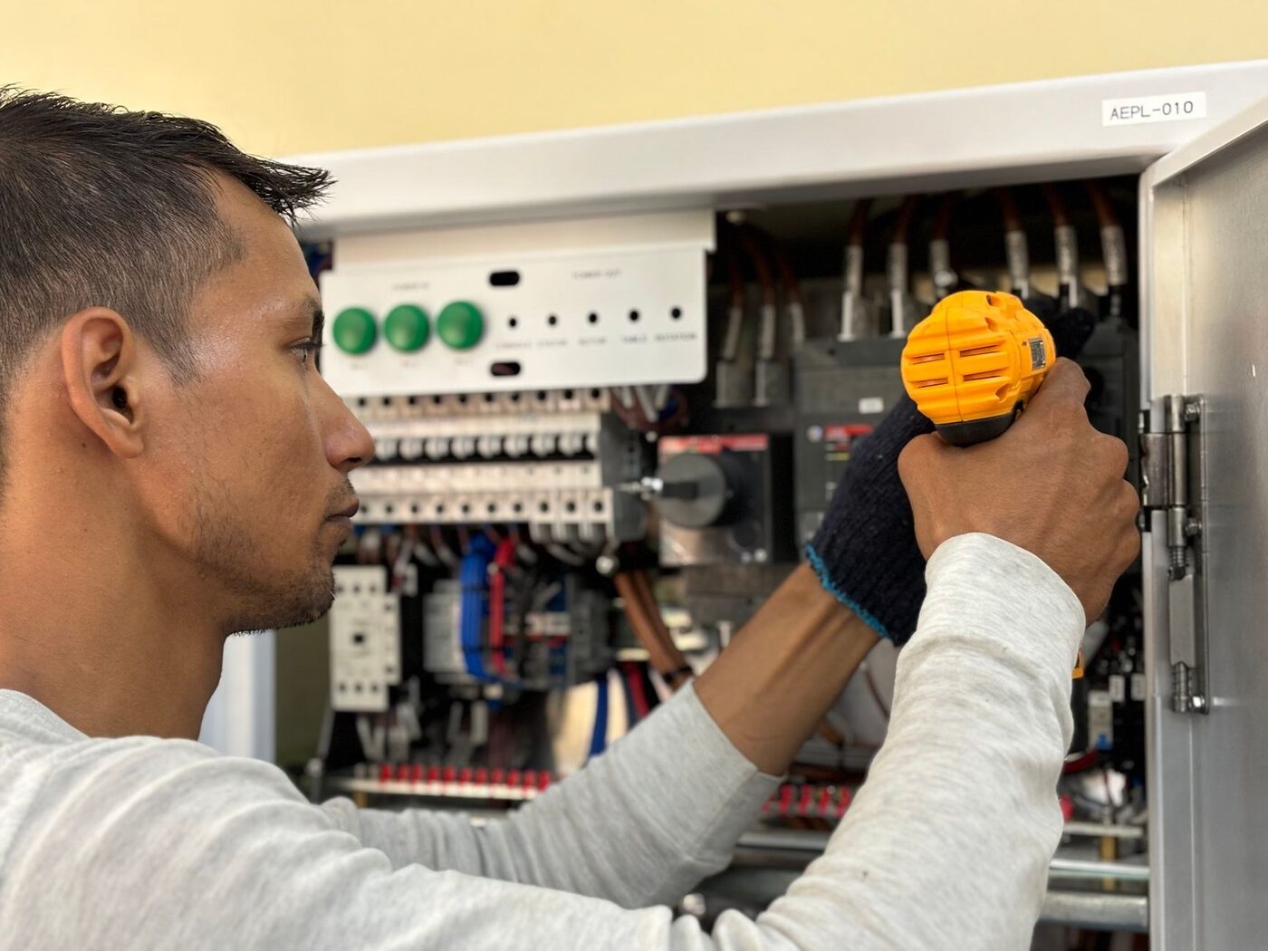 Electrician working inside an open switchboard